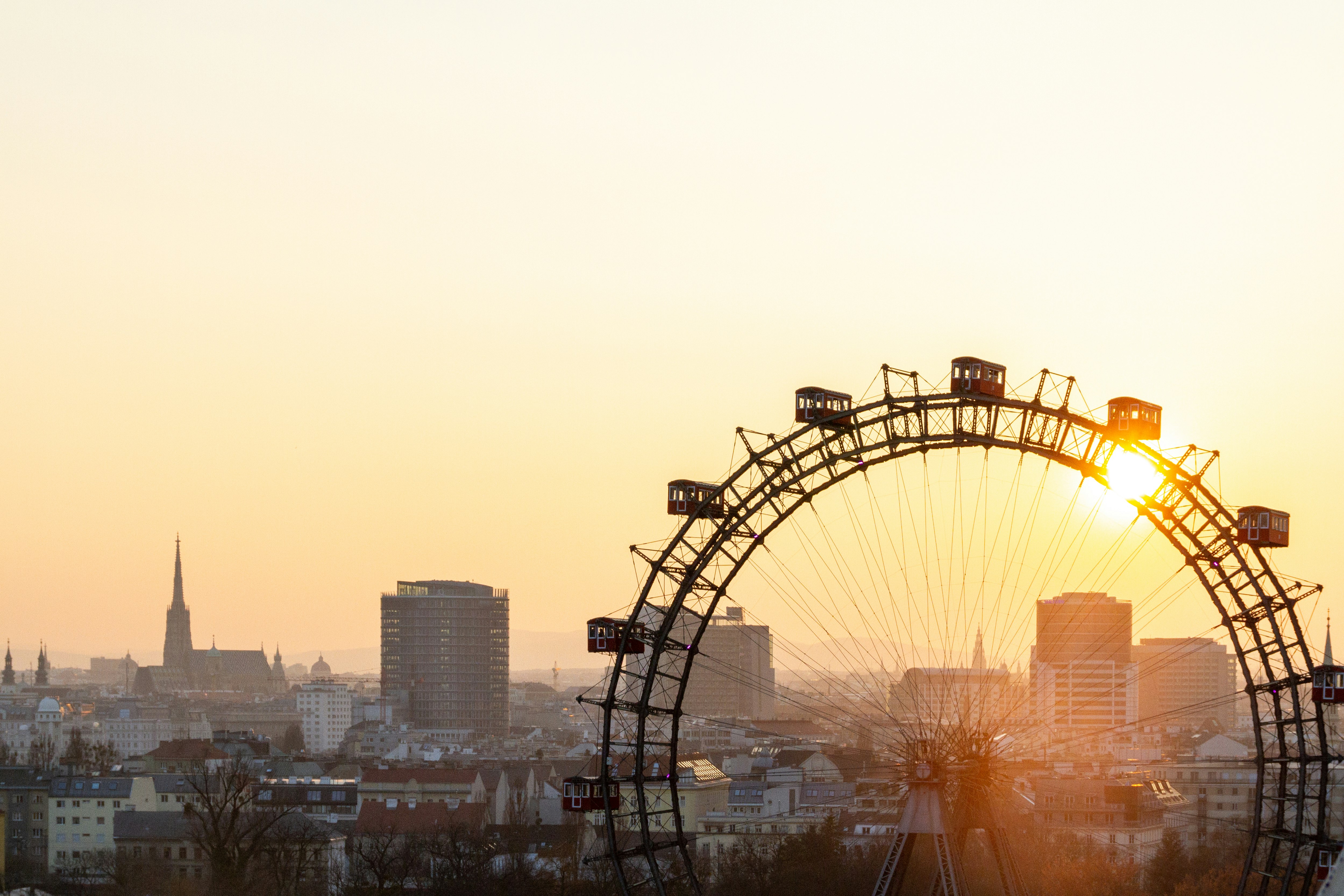 ferris wheel near city buildings during sunset